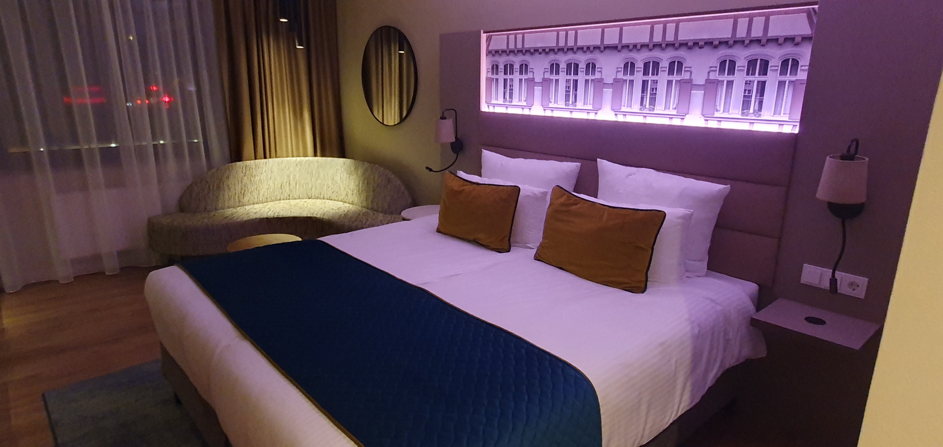 Bett in lilafarbenem Ambiente-Licht im Hotel Leonardo in Esslingen